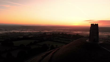 panning aerial of the misty sunrise over glastonbury tor and the somerset levels