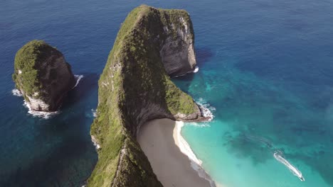 aerial tilt shot over a cliff showing nusa penida kelingking beach over cliffside
