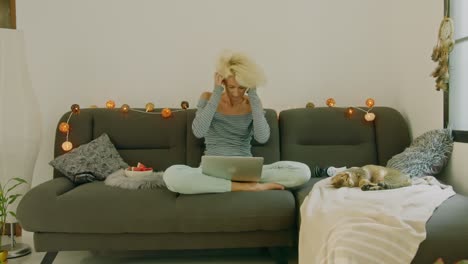 woman relaxing on a couch using a laptop