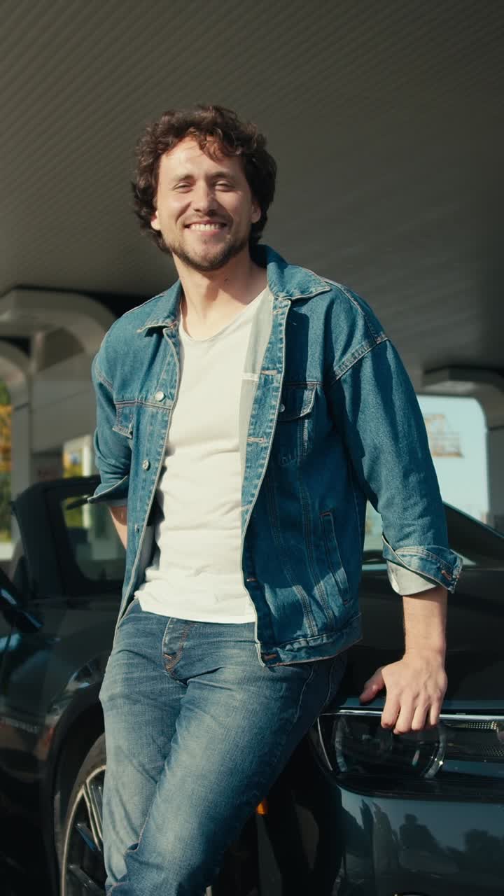 Man leaning on a sports car at a gas station
