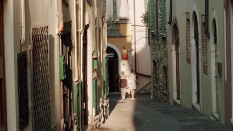 mujeres caminando en una pequeña calle de desenzano del garda al atardecer