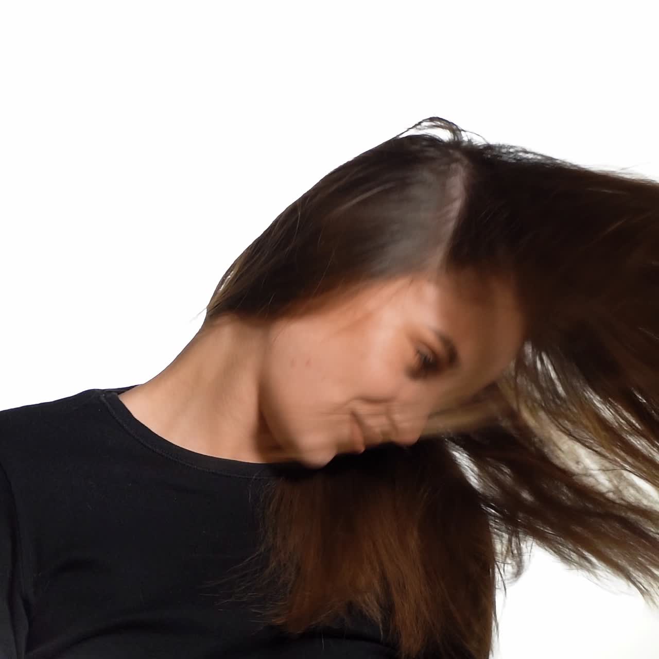 Beautiful woman waving her hair. Laughing woman covers her face with long hair. Shaking her hair. Slow motion.