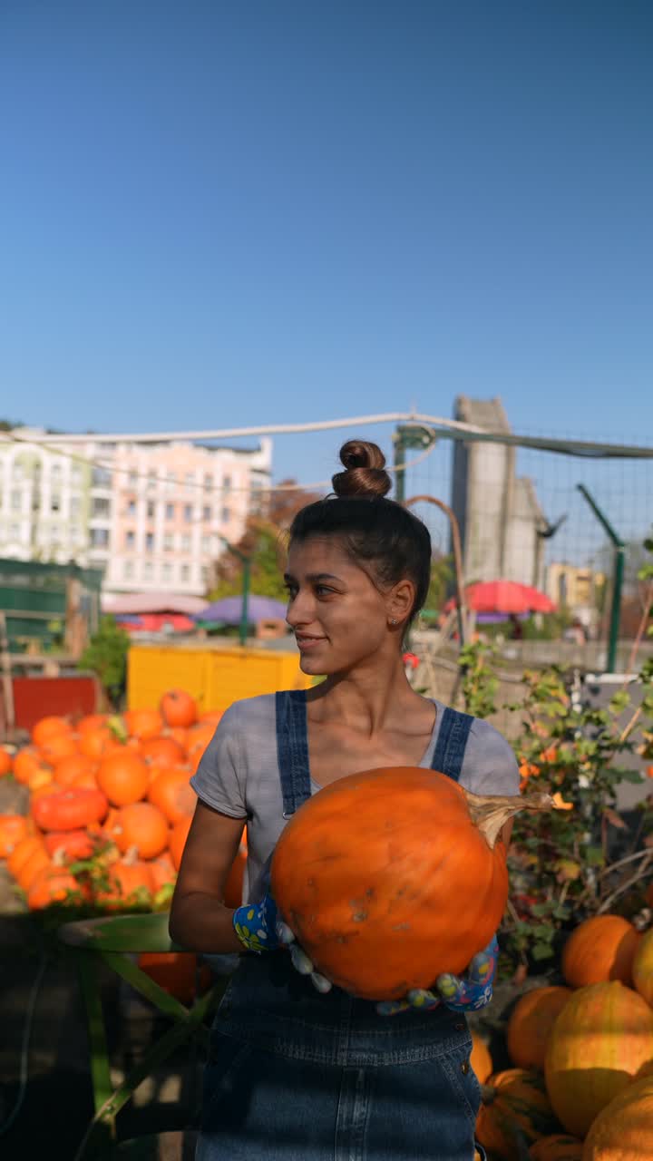 농부 시장 에서 호박 을 들고 있는 여자