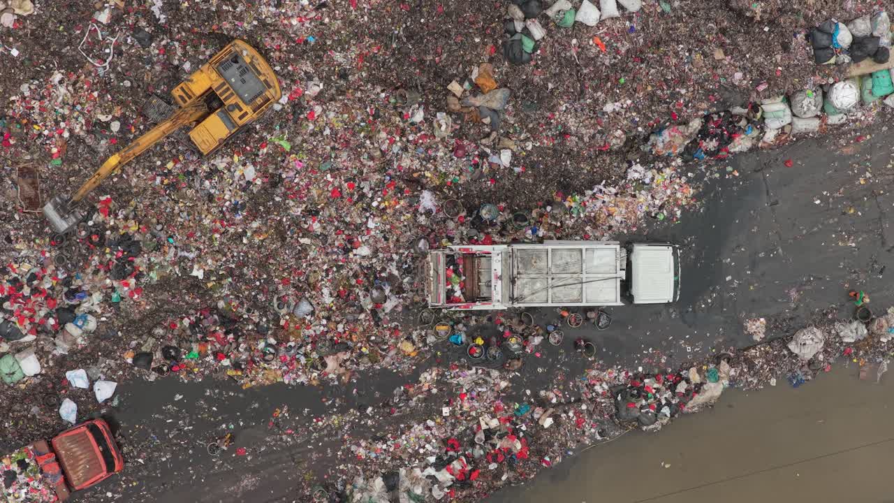 Vista aerea di autocarri per la raccolta rifiuti in una grande discarica.