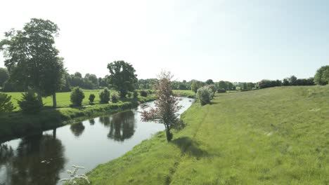 river slaney flowing through the green grassland and farm on a sunny day in ireland