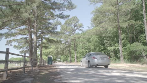 a car is driving down a road with trees