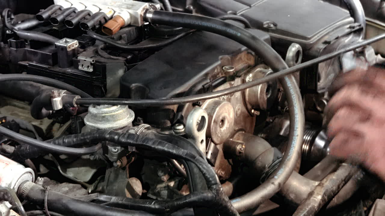 Man with dirty hands working on the engine bay of a car