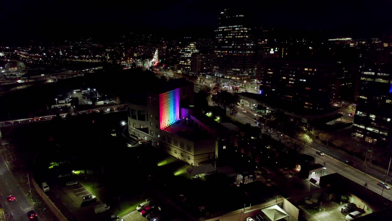 교통 체증이 있는 거리 한복판에 lgbt 깃발 색깔이 있는 건물의 정적인 조감도