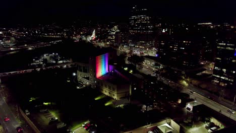static aerial view of a building with the colors of the lgbt flag in the middle of the streets with traffic