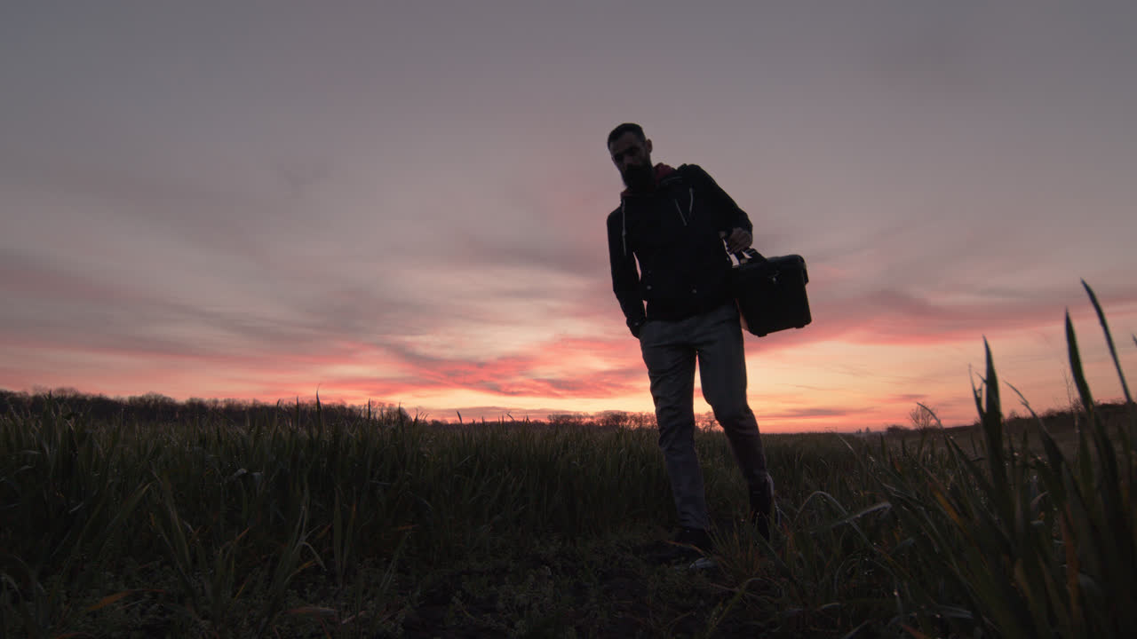 Man watching step walking in field agriculture hard case carry field wet grass