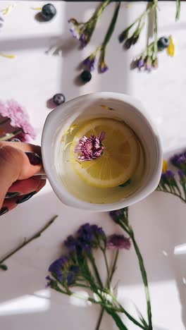 mano con una refrescante limonada floral
