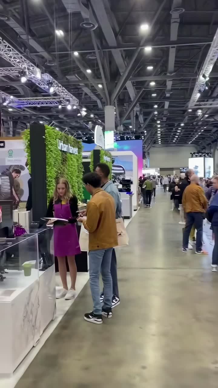 Video grandangolare di un vivace salone fieristico, che cattura interazioni dinamiche ed esposizioni moderne