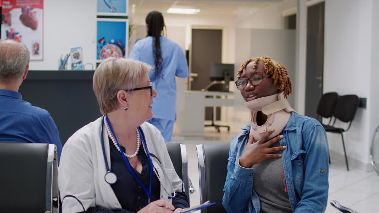 Doctor consulting patient with neck brace in hospital waiting room