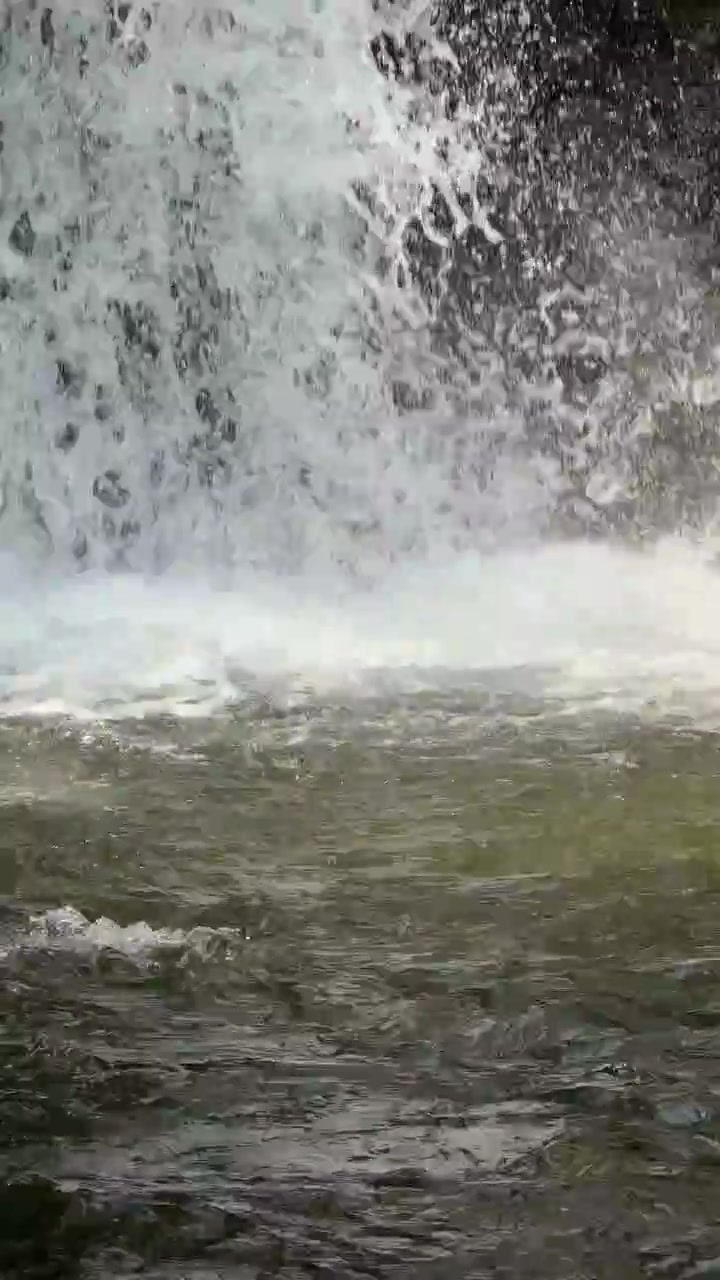 Primo piano di acqua che scende a cascata da una cascata rocciosa