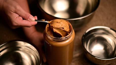 sacar mantequilla de maní con una cuchara de metal