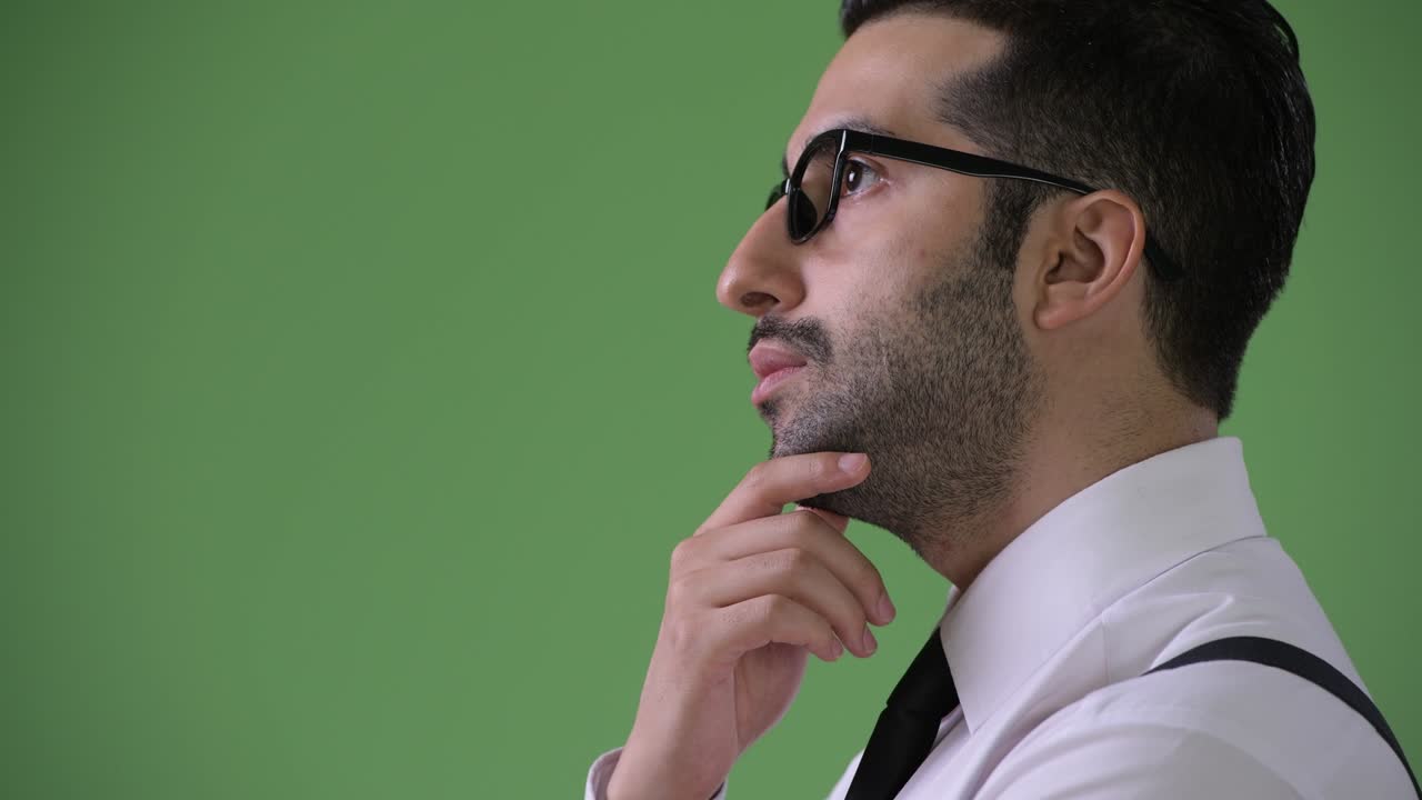 joven empresario persa barbudo y guapo contra un fondo verde