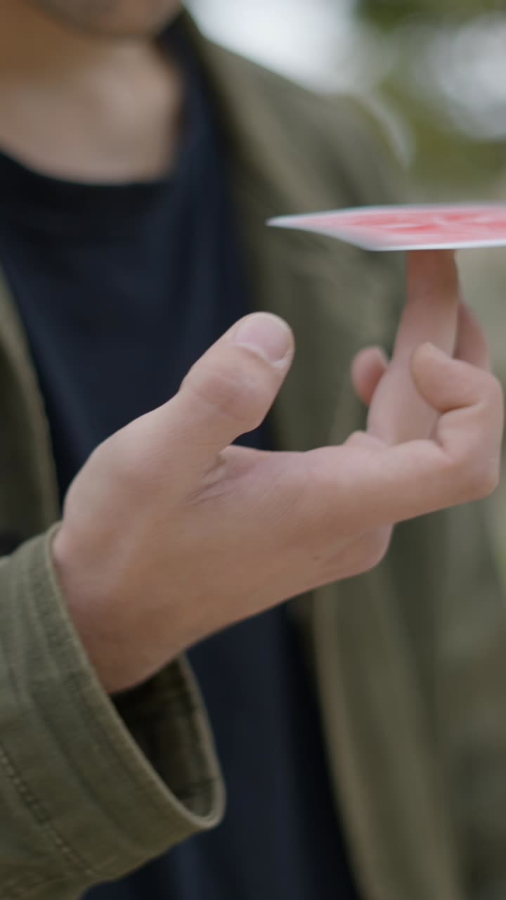 A Person's Hand Balancing a Playing Card on a Finger