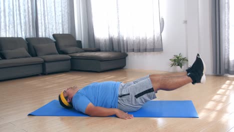 overweight man doing abdominal exercises at home in his living room