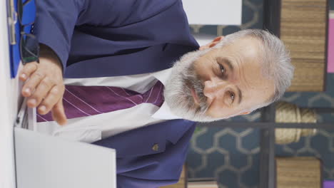 video vertical de un viejo hombre de negocios emocional mirando a la cámara.