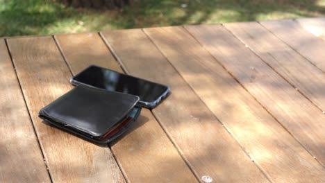 wallet and phone on wooden table