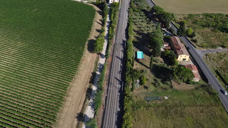 sieci town highway, railway tracks alongside green vineyards, tuscany, italy