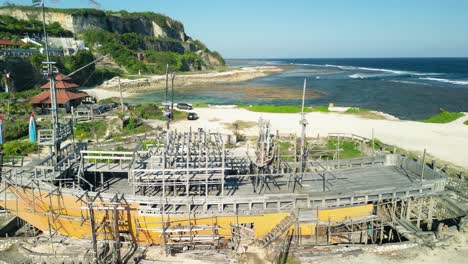 sitio del naufragio de bali melasti ungasan con vista de la costa y arquitectura indonesia - grúa aérea hacia arriba