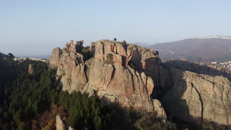 Slow-pull-in-aerial-drone-shot-of-the-natural-rock-formations-that-houses-a-fortress-at-the-fore-of-Balkan-mountain-range,-in-the-province-of-Vidin-in-Bulgaria