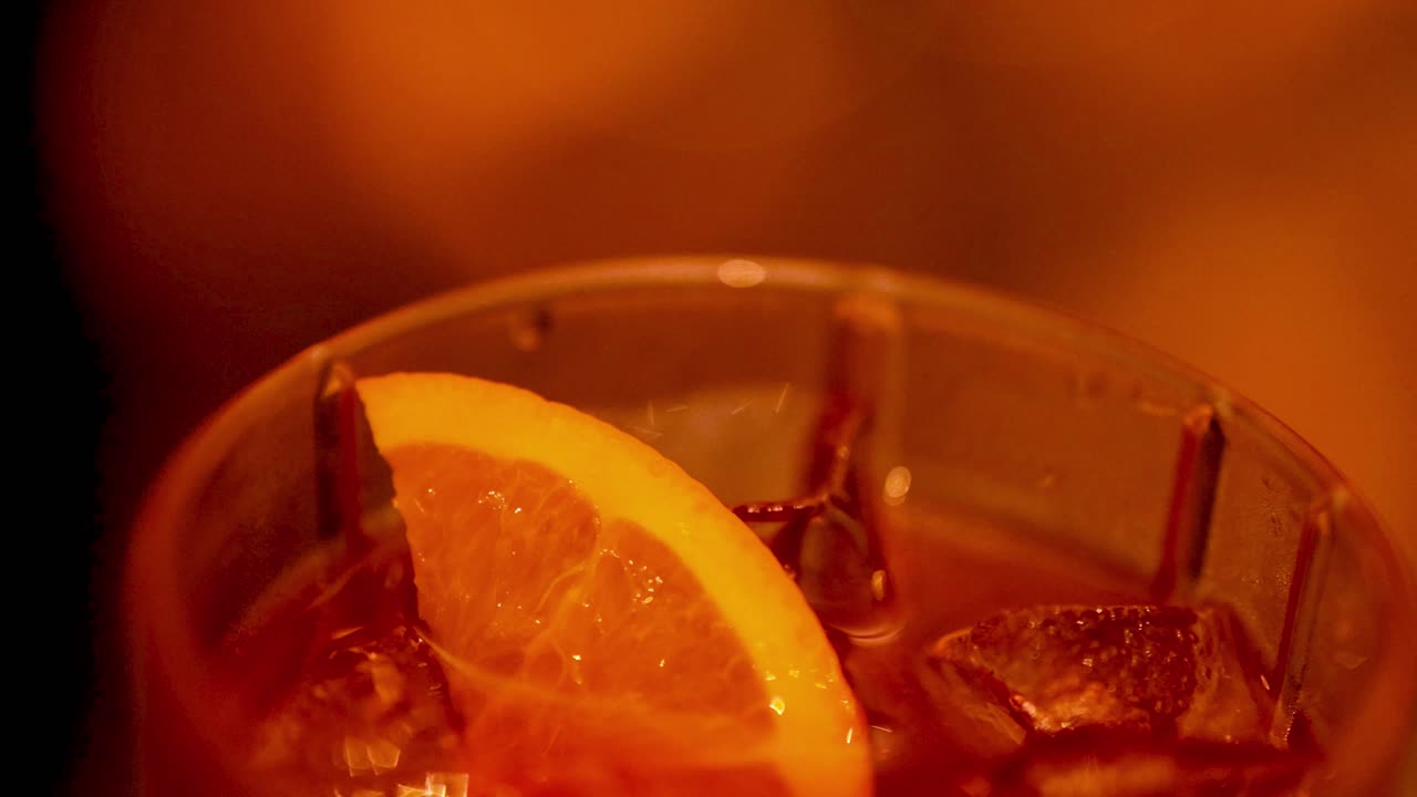 primer plano de un cóctel de negroni con una rebanada de naranja