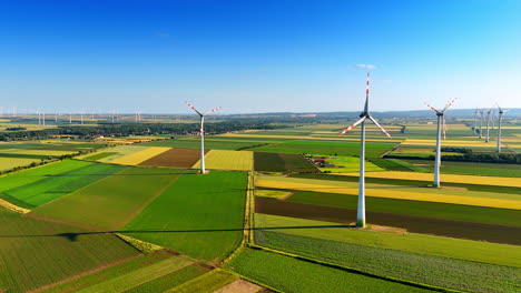 windmills rotate in the wind in the countryside. aerial perspective on the wind farms producing green energy.