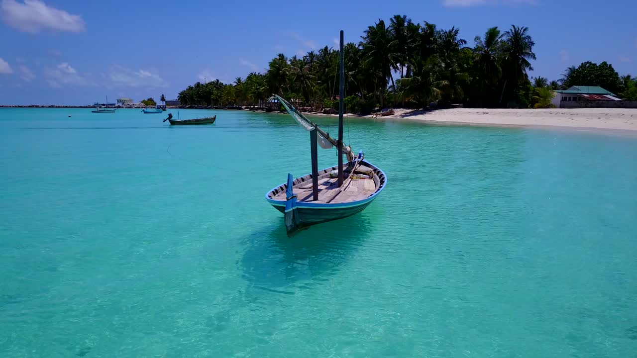 카리브해의 얕은 청록색 바다에 떠 있는 작은 범선의 저고도 조감도