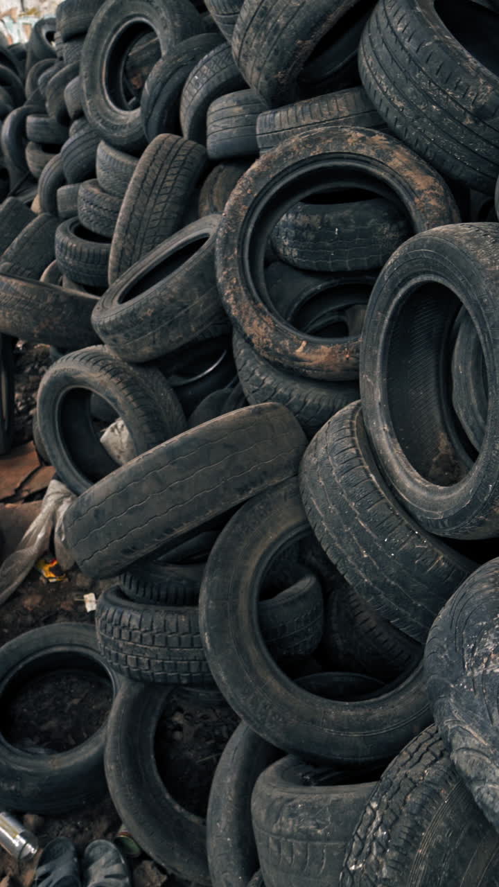 Lot of old tires from cars. Second hand tyres stacked up at old dump Vertical video