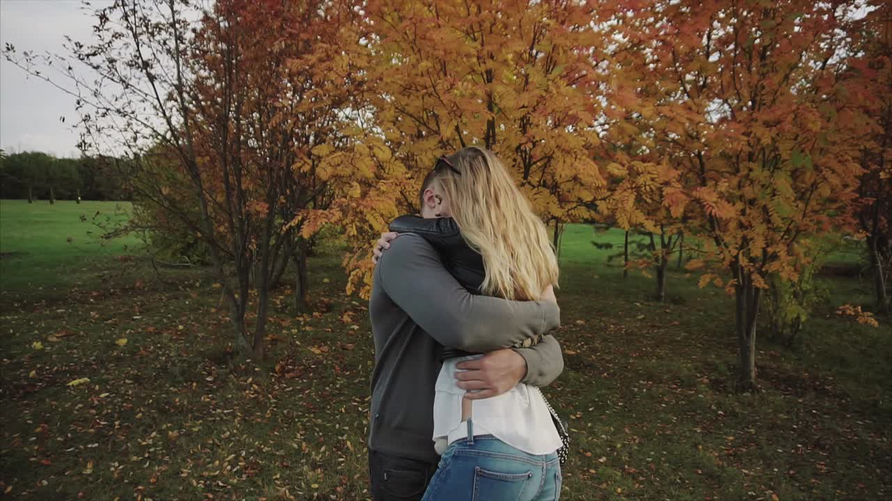 una pareja abrazándose en el parque de otoño.