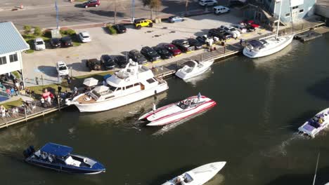 vista aérea de personas en lancha motora junto a un yate de lujo en el puerto deportivo