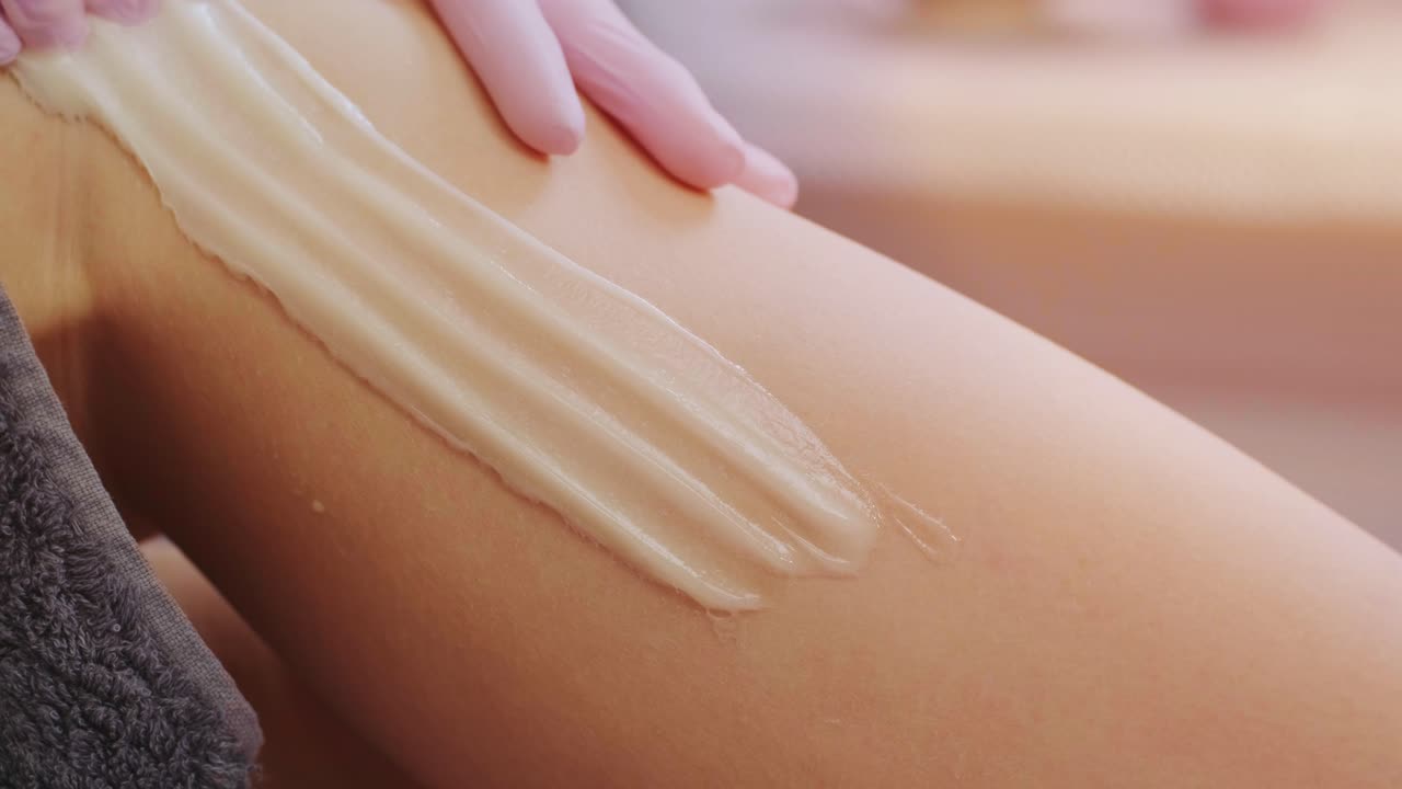 Female legs depilation by honey or sugar pasta. Sugaring hair removal. Beauty concept. Sugaring. Epilation process. Legs.