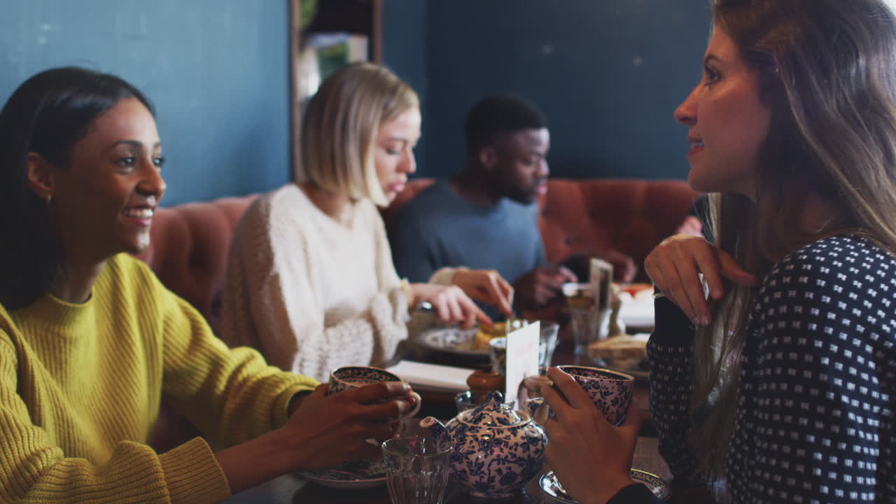 Group Of People Meeting In Restaurant Of Busy Traditional English Pub