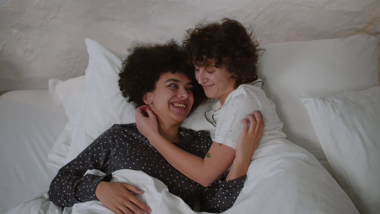 pareja feliz acostada en la cama