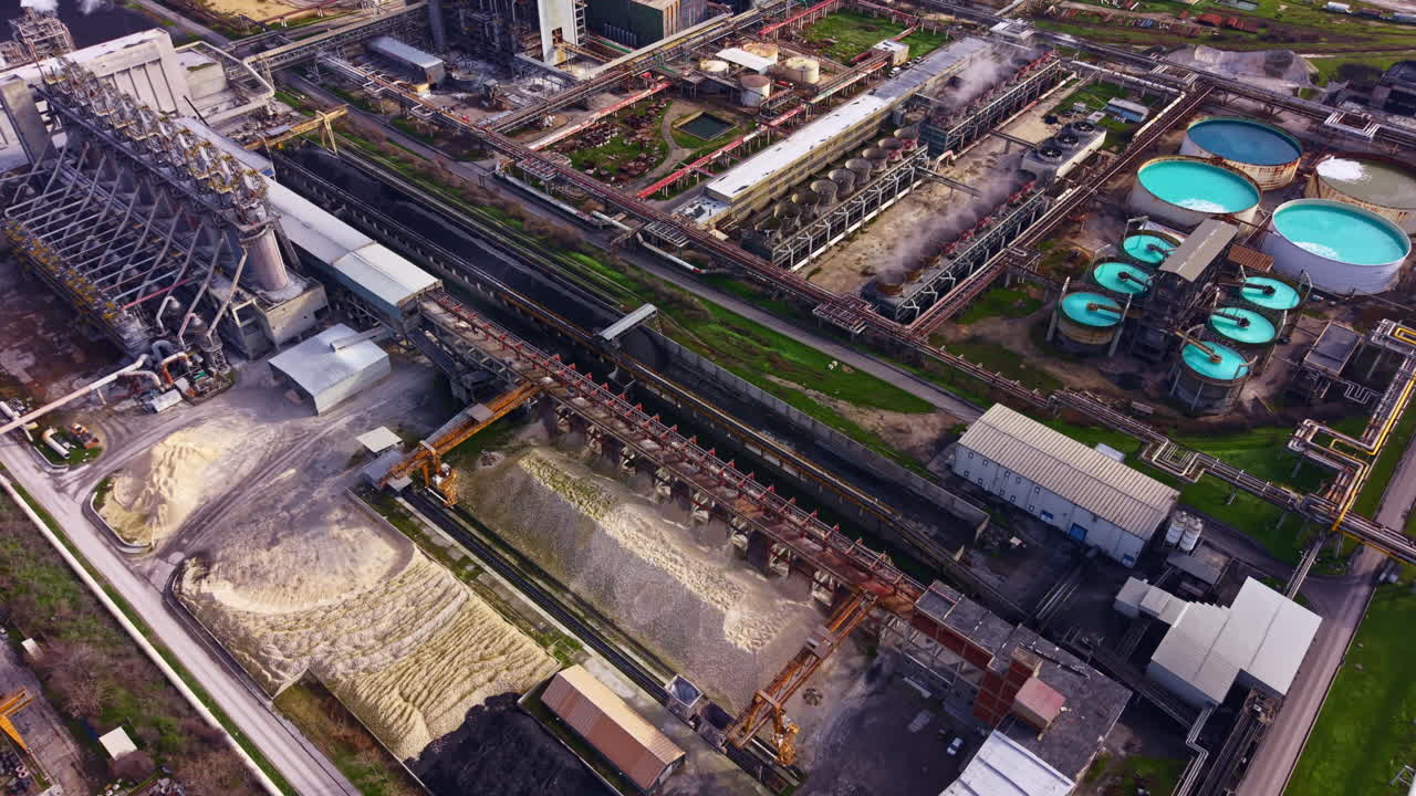 Impianto industriale in funzione con vari impianti e attrezzature visti dall'alto di giorno.