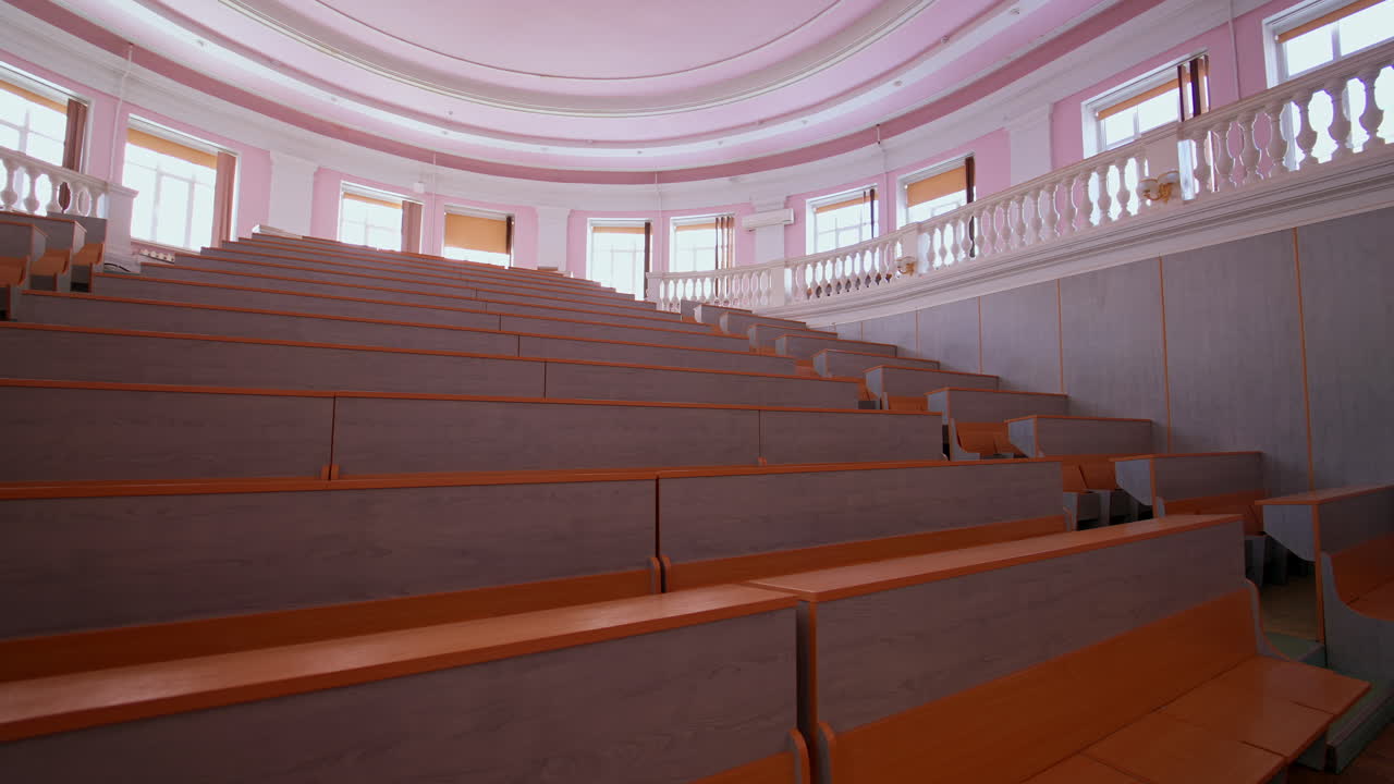 Lecture hall with nobody. Modern educational auditorium in the university. Interior of a large empty classroom during coronavirus pandemic.