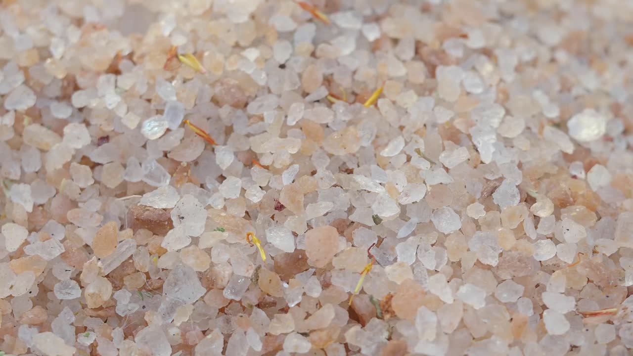 Primo piano di cristalli di sale rosa e bianco a grana grossa