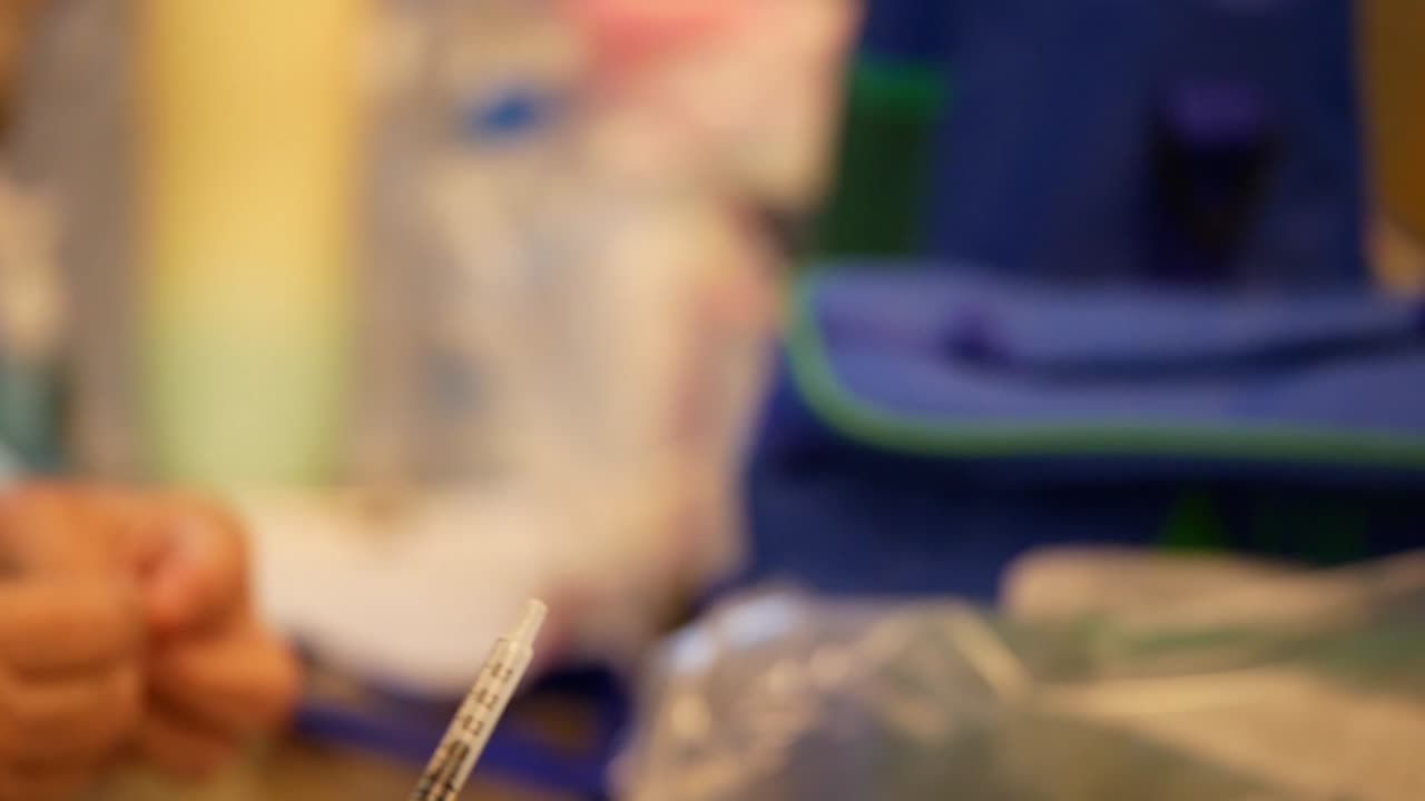 imágenes de cerca de una enfermera registrada que saca el refuerzo de la vacuna covid-19 usando una jeringa