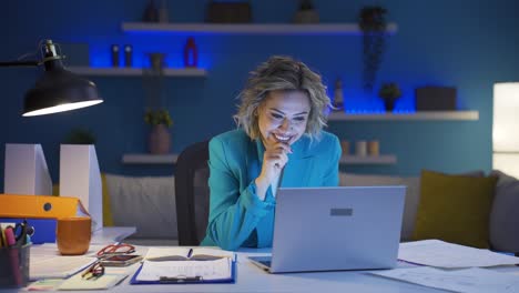 una donna che lavora in un ufficio a casa con un'espressione soddisfatta.