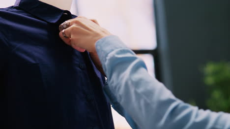 worker arranging shirt on mannequin