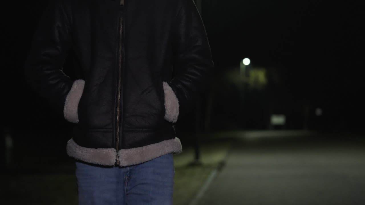Man walks alone down an empty street at night with hands in his pockets, creating a quiet, isolated atmosphere. Concept for loneliness, depression, solitude, and late-night reflection