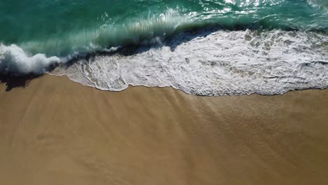 aerial view of a beautiful beach with turquoise water and white waves
