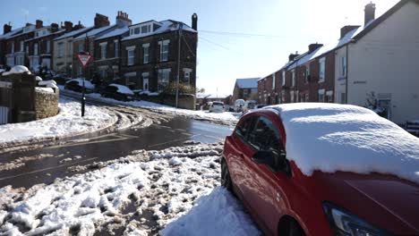 Abandoned-red-car-crashed-into-brick-wall-during-snow-in-residential-area