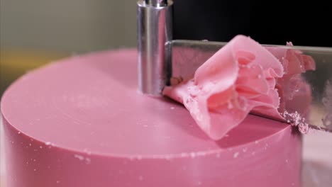 confectioner is making a petals from pink chocolate on round cutter