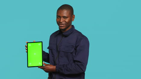 joyful private law enforcement worker presenting chroma key tablet