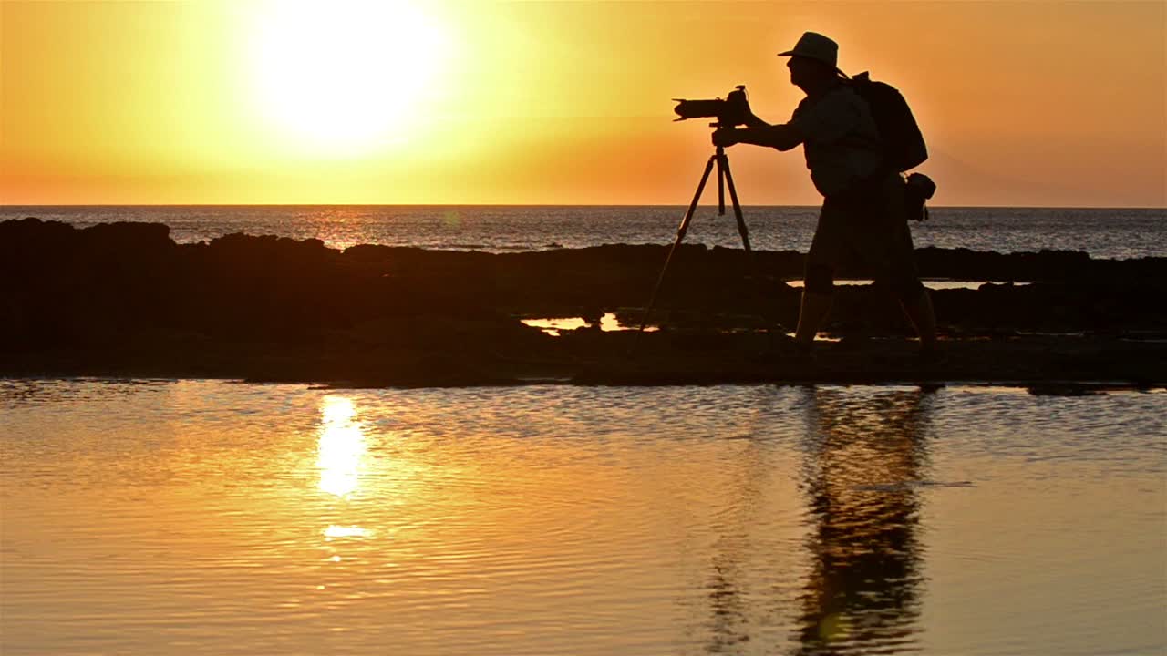 갈라파고스 제도 국립공원의 산티아고 섬 푸에르토 에가스에서 사진작가의 실루엣과 일몰