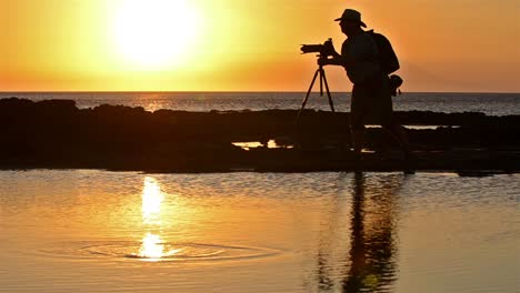 photographers silhouette and sunset at puerto egas on santiago island in the galapagos islands national park