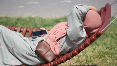 una mujer relajándose en un columpio.